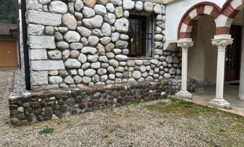 Muratura esterna in pietra a vista con giunti di malta e basamento
