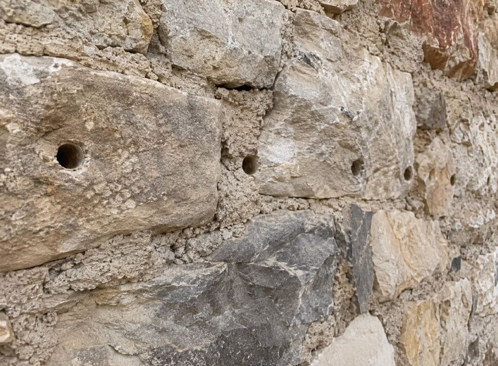 Fila di perforazioni che interessa sia le pietre sia i giunti di malta